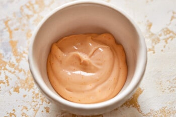 a bowl of orange sauce on a table.