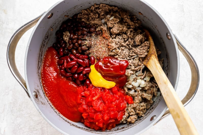 ingredients in a pan with a wooden spoon.