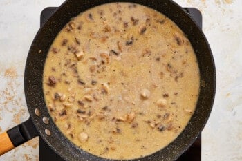 a frying pan filled with a sauce and mushrooms.