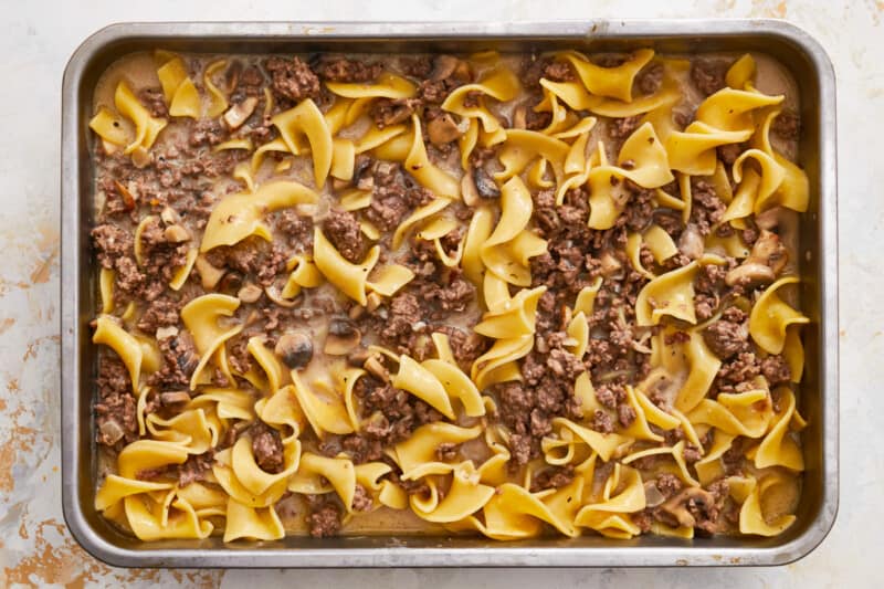 a casserole dish filled with noodles and meat.