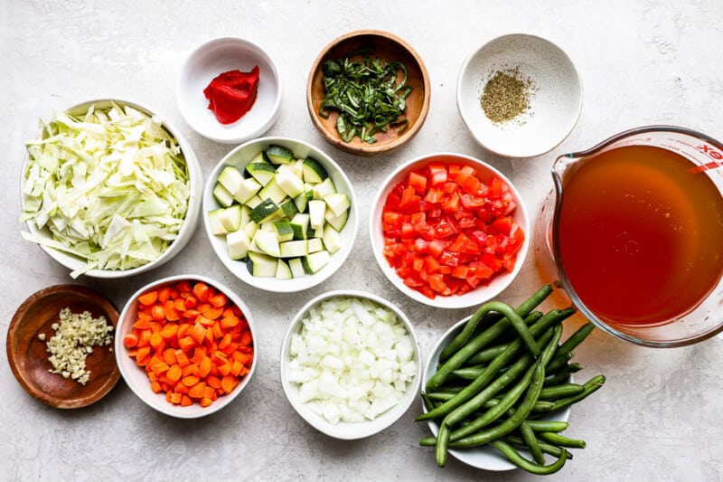 overhead view of ingredients for cabbage soup in individual bowls.