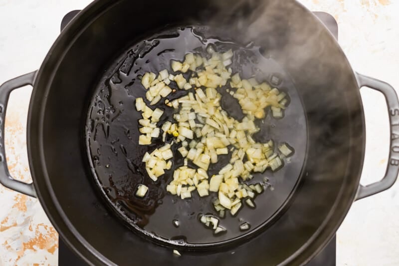 sauteing onions and garlic in a pan.