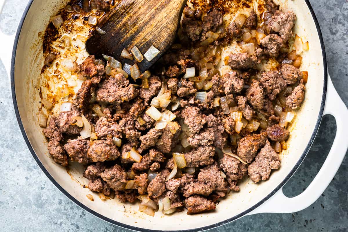 A skillet filled with meat and onions.