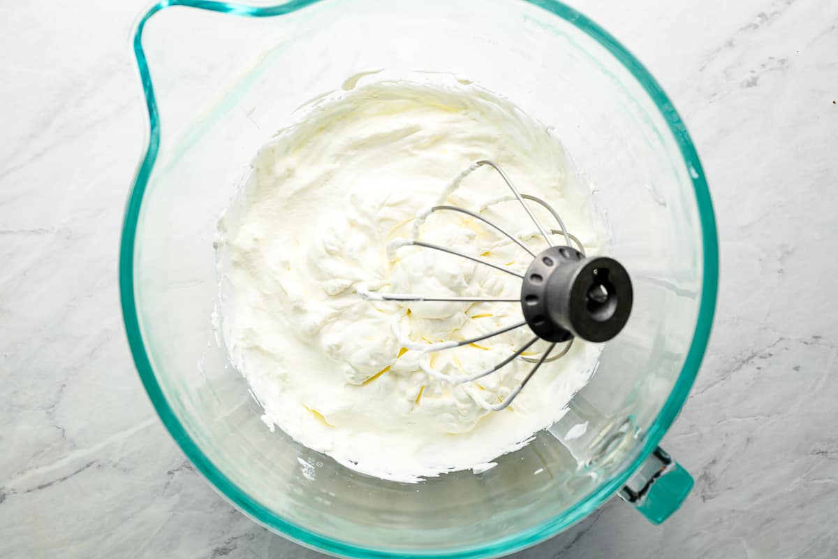 whipped cream in a glass mixing bowl.