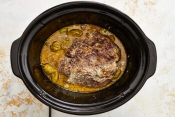 a slow cooker filled with meat and vegetables.