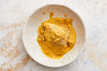a white bowl with a scoop of pumpkin ice cream.