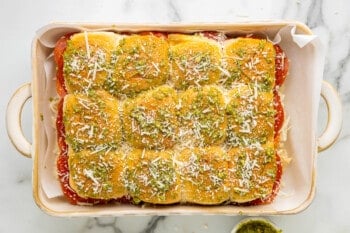 a white baking dish with a pizza on it.