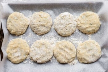a baking sheet with several dough balls on it.