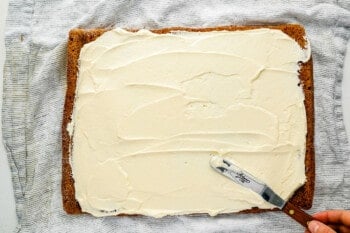 a person cutting a piece of cake with a knife.
