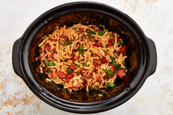 a crock pot filled with spaghetti and meatballs.