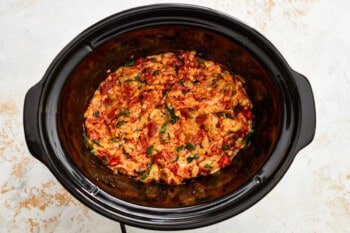 a crock pot filled with meat and vegetables.