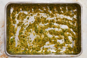 a baking pan filled with green pesto.
