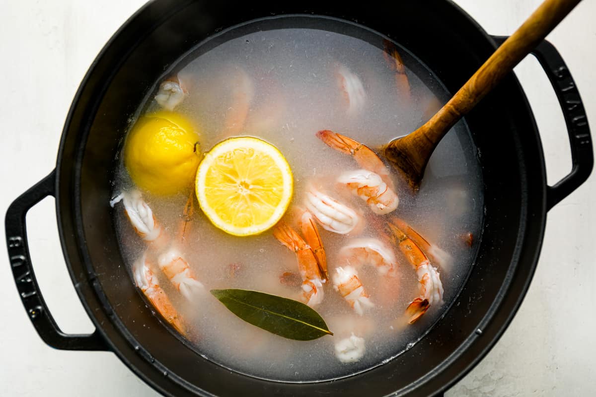 a pot with shrimp and lemon in it.