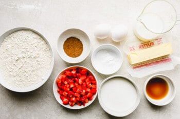 the ingredients for a strawberry cake are laid out on a table.