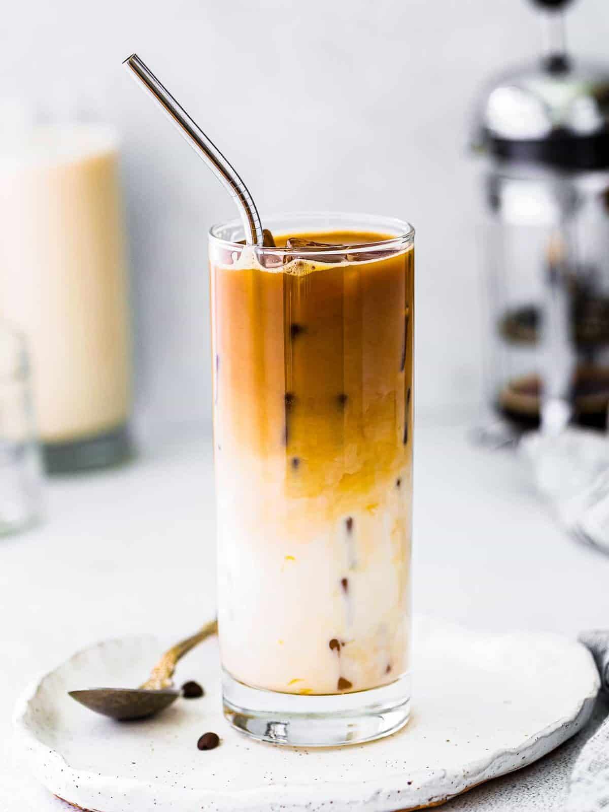 iced caramel macchiato in glass with metal straw