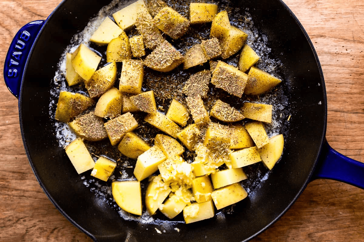 Seasoned potatoes in a skillet. 