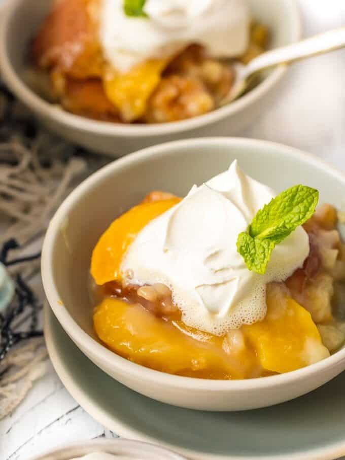 homemade peach cobbler recipe in bowls with cream
