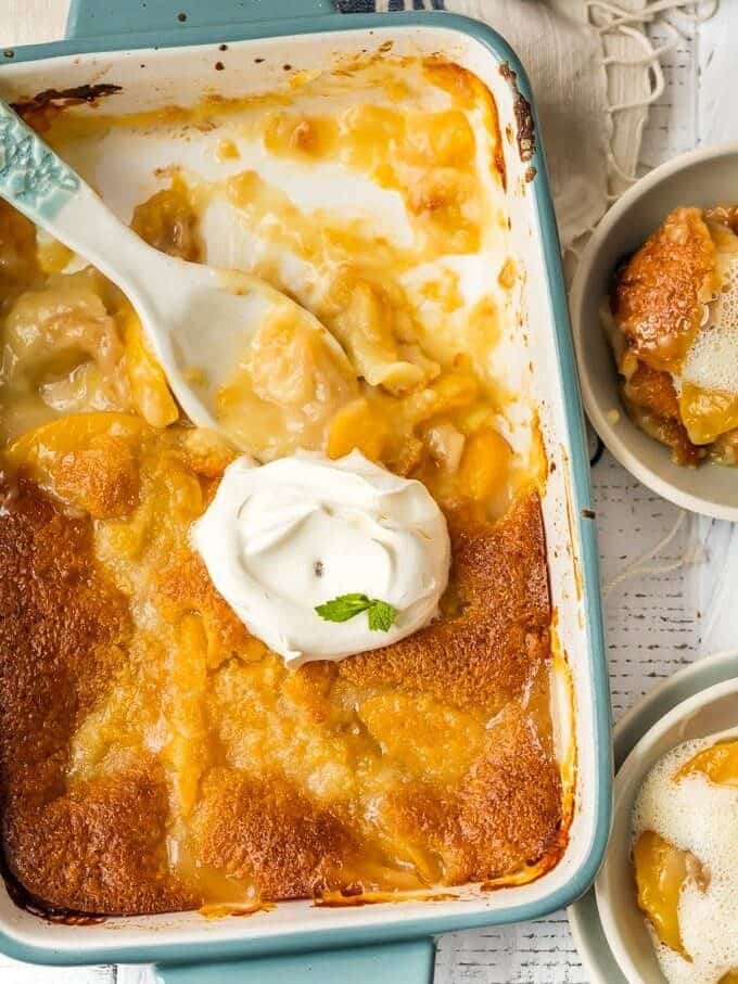 peach cobbler recipe in pan with cream