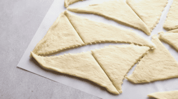 crescent roll dough sliced into small triangles.