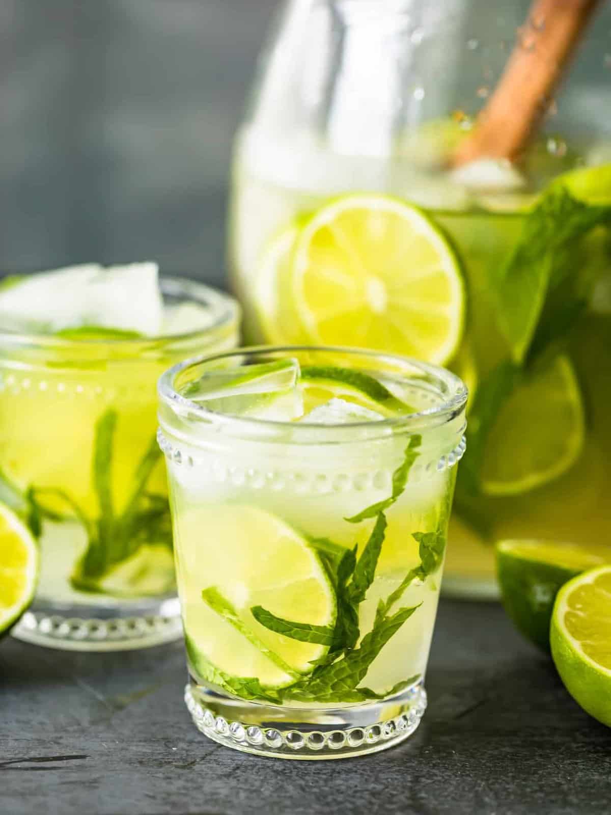 glasses of mojitos next to a pitcher