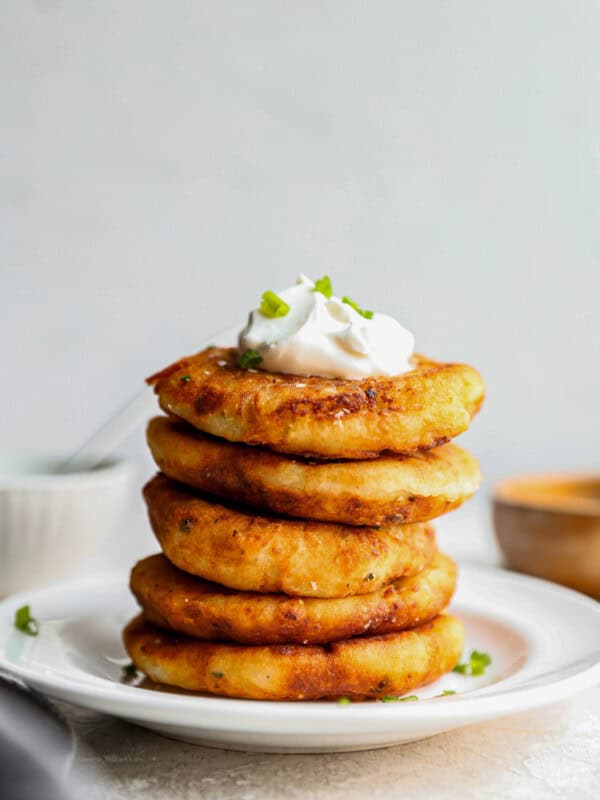 a stack of pancakes topped with sour cream and chives.
