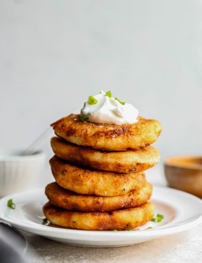 a stack of pancakes topped with sour cream and chives.