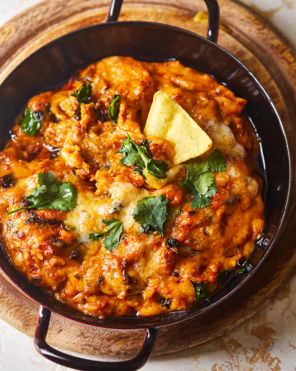 chicken tikka masala in a pan on a wooden table.