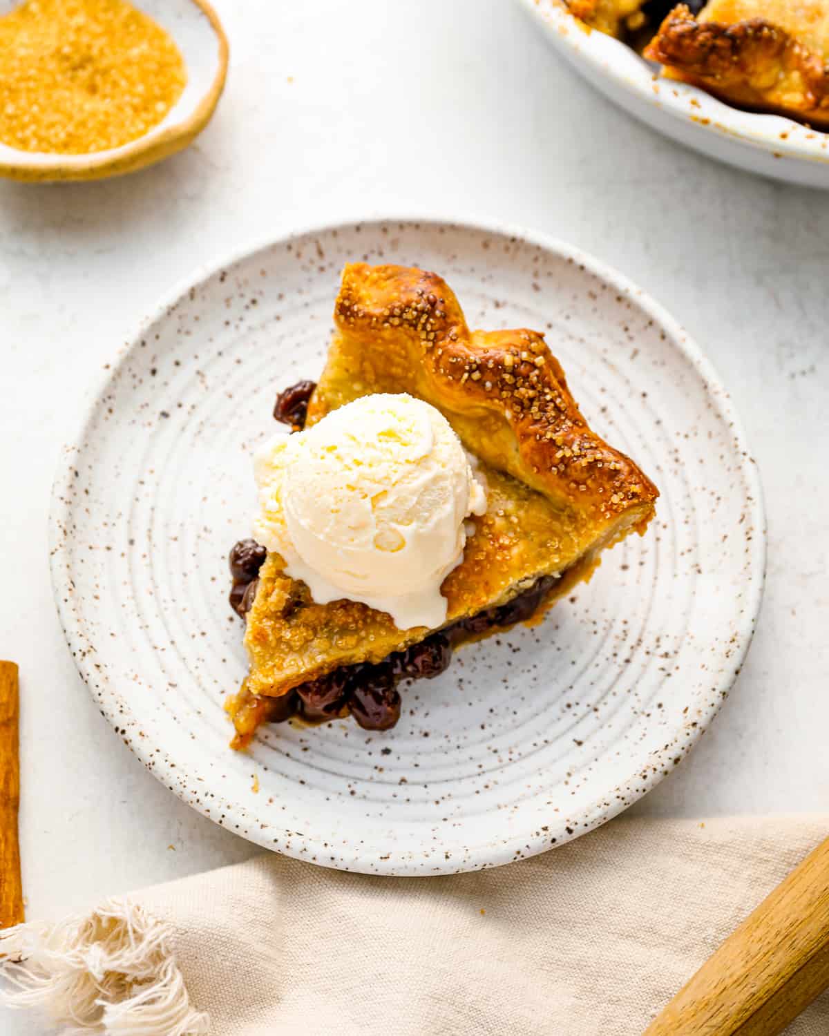 a slice of raisin pie with ice cream on a plate.