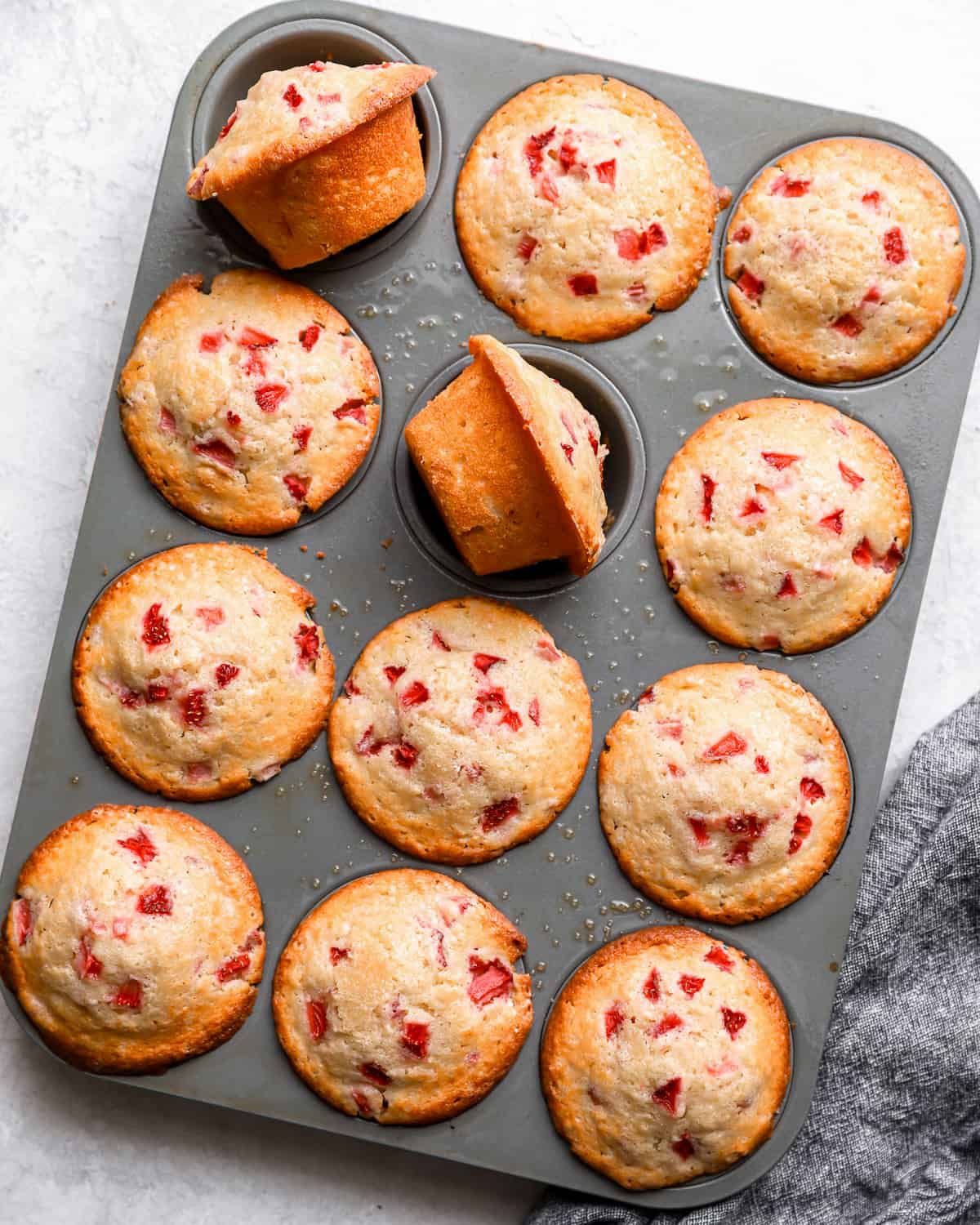 fresh strawberry muffins in a muffin tin.
