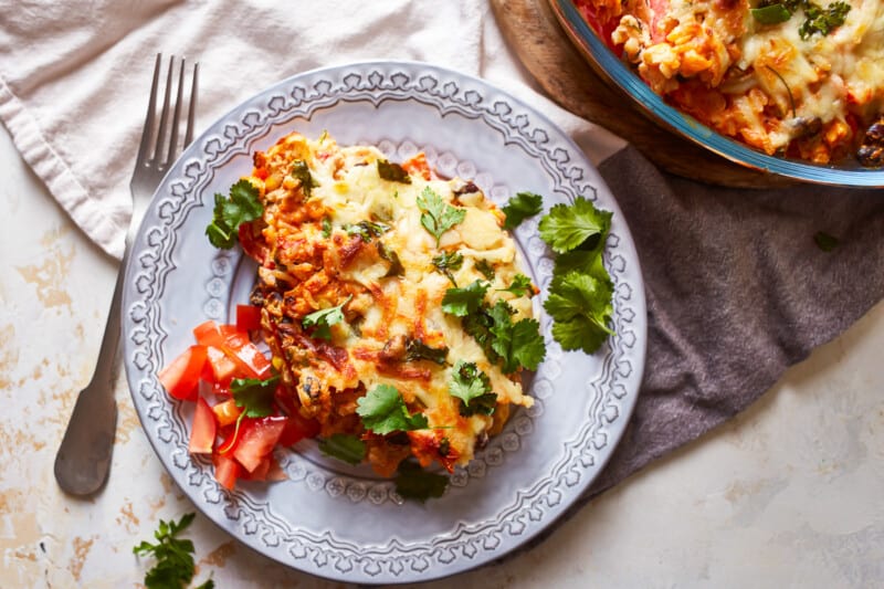 mexican lasagna on a plate with a fork.