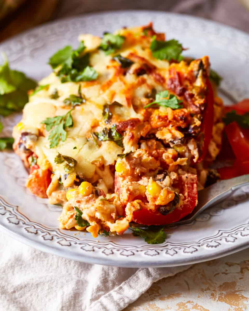 mexican lasagna on a plate with a fork.