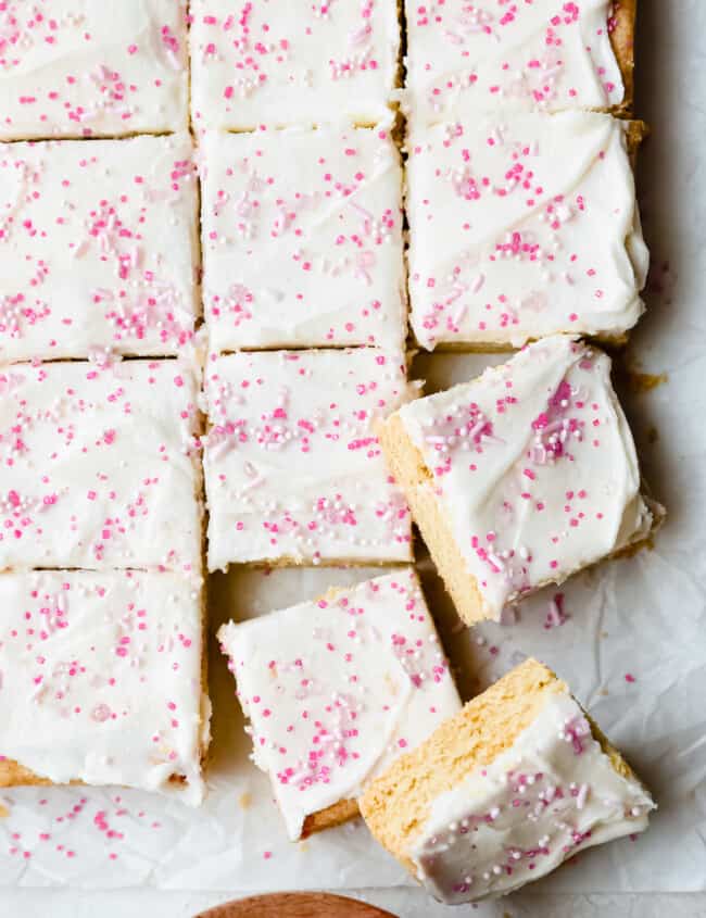 a sheet of white and pink frosted bars on a baking sheet.