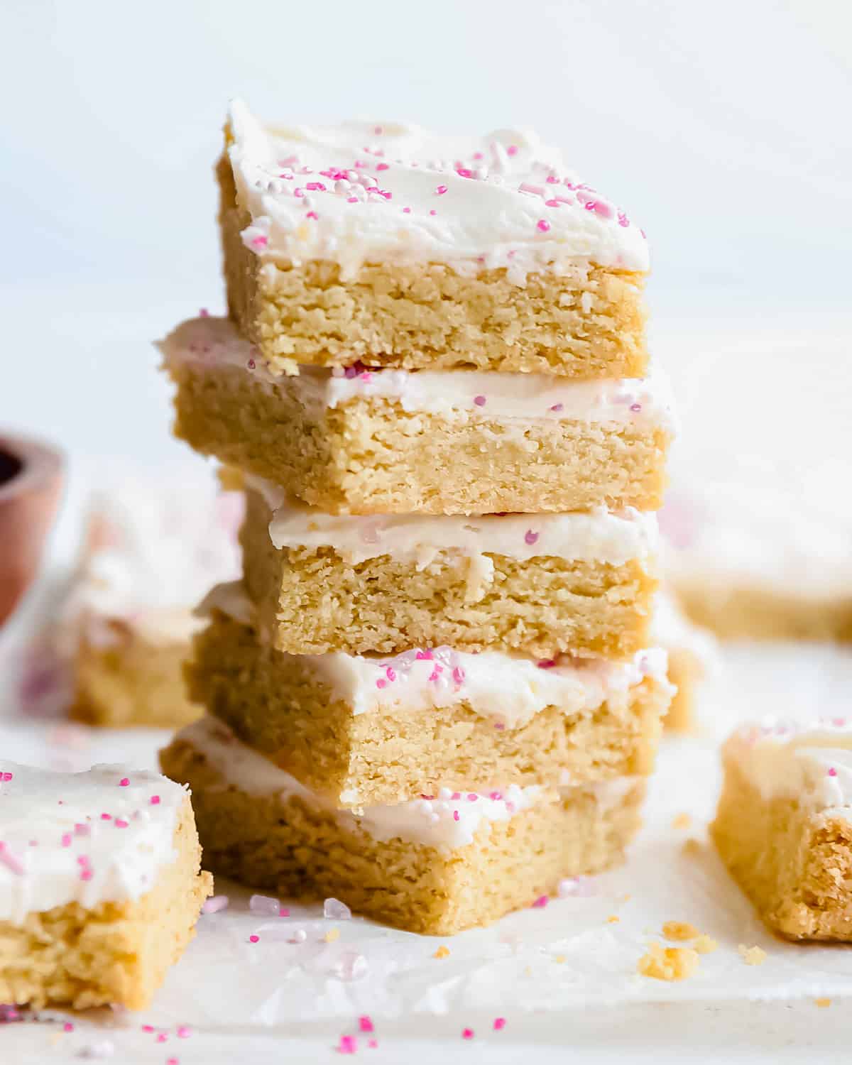 a stack of sugar cookie bars with icing and sprinkles.