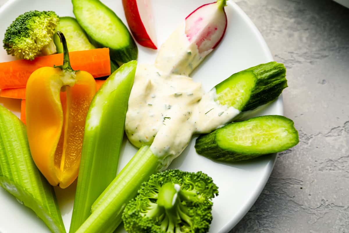 a plate of vegetables with a small dab of dip on it.