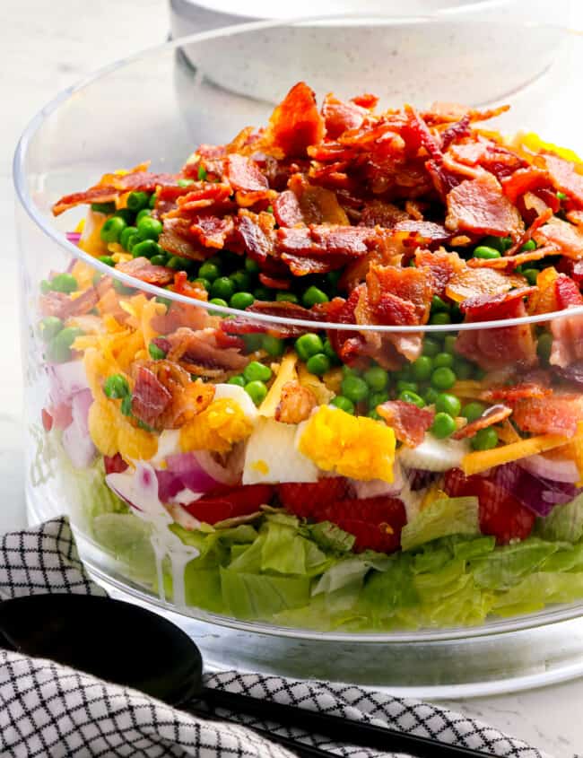 A salad with bacon and peas in a bowl.