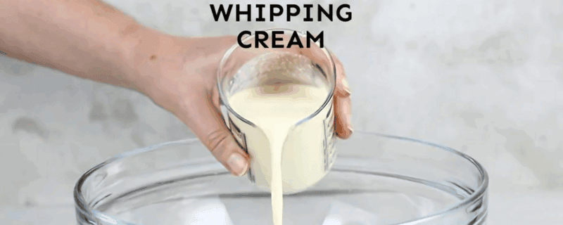 Preparing the whipped cream topping for the cake.