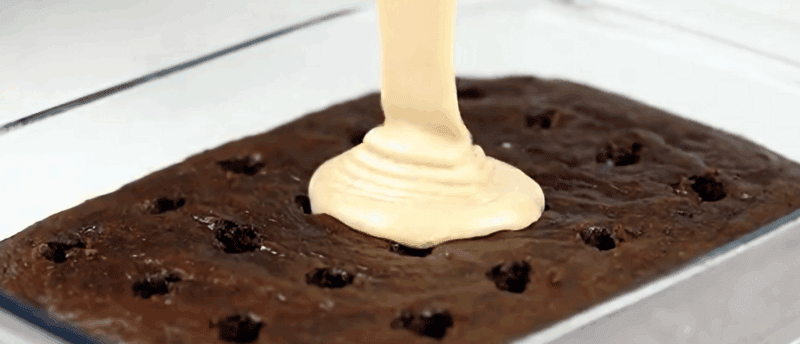 Pouring the topping over the cake.