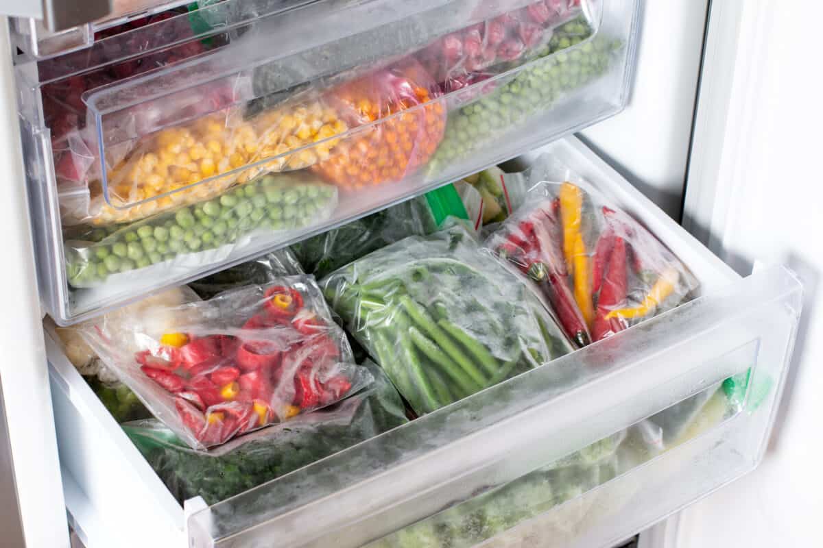 A refrigerator stocked with frozen vegetables and fruits.
