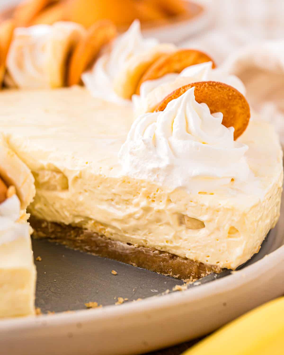 close up on a banana pudding cheesecake, with one slice removed.