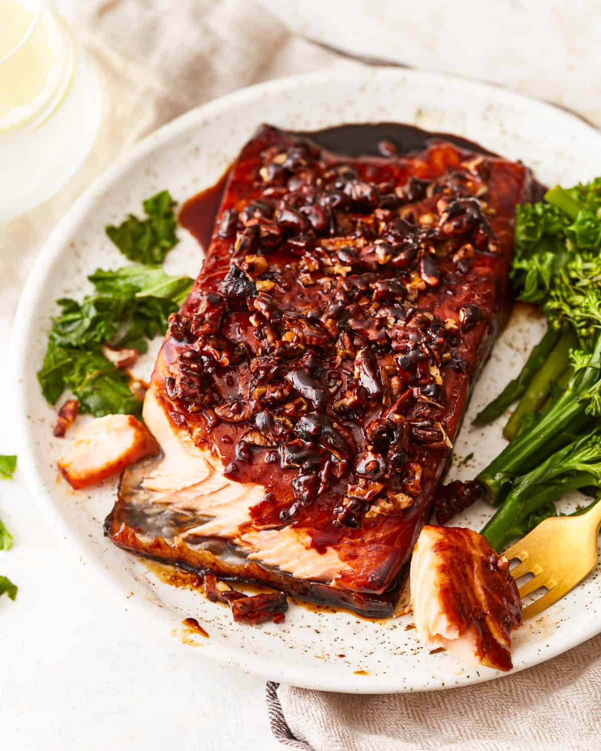 A plate with brown sugar salmon and greens on it.