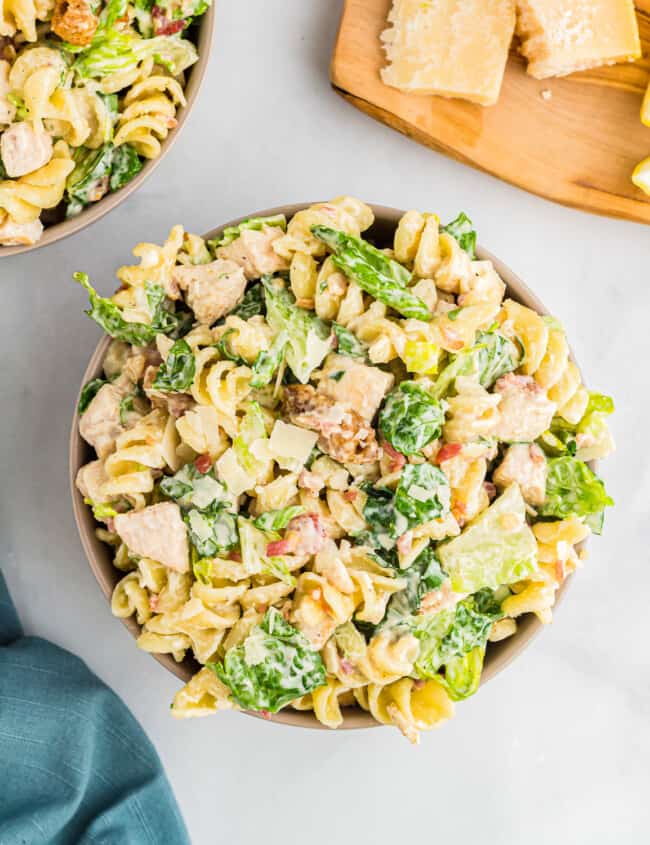 Two bowls of pasta salad with chicken and lemon.