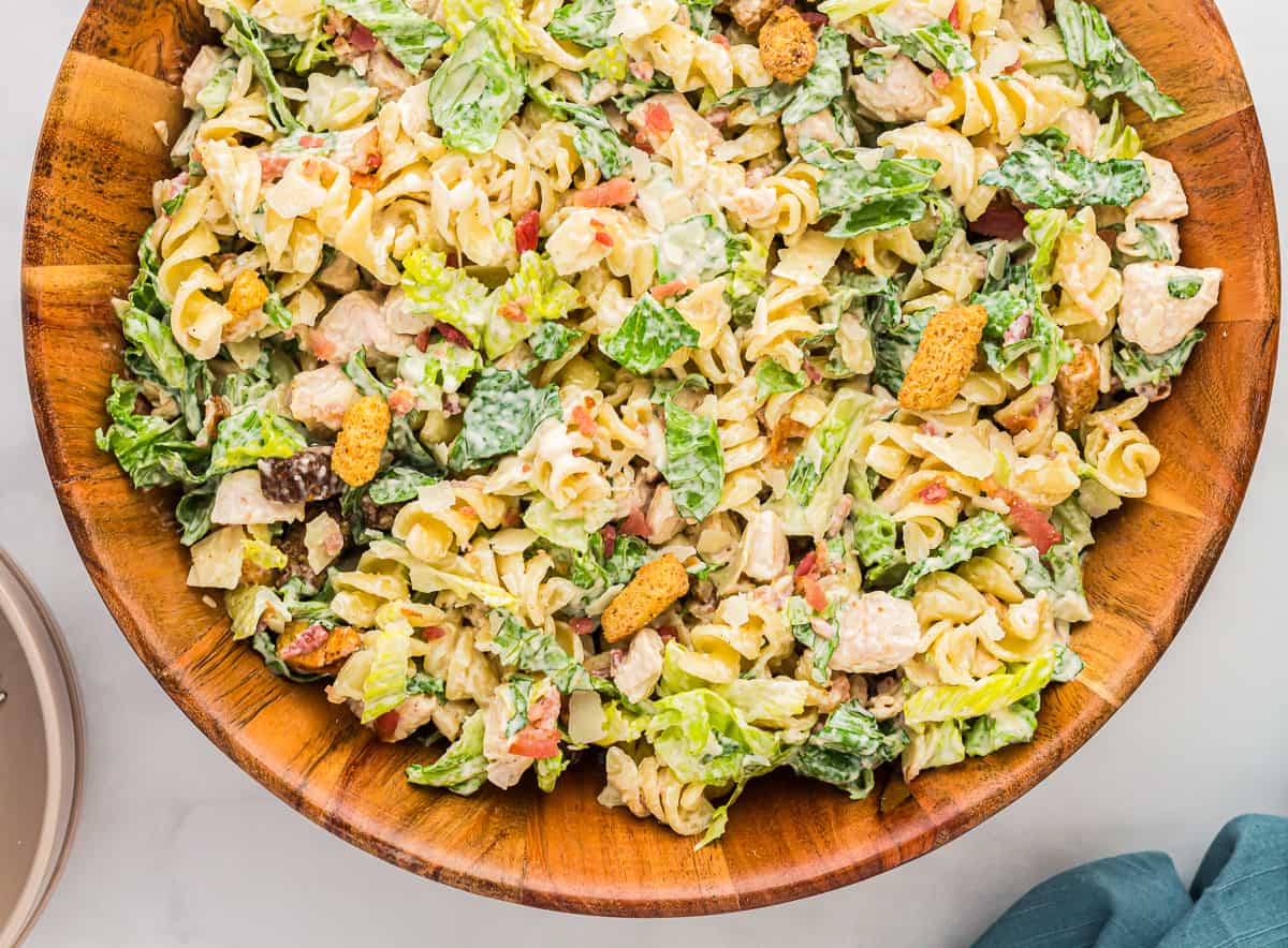 Chicken Caesar pasta salad in a wooden bowl.