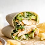 A chicken burrito with lettuce and chips.