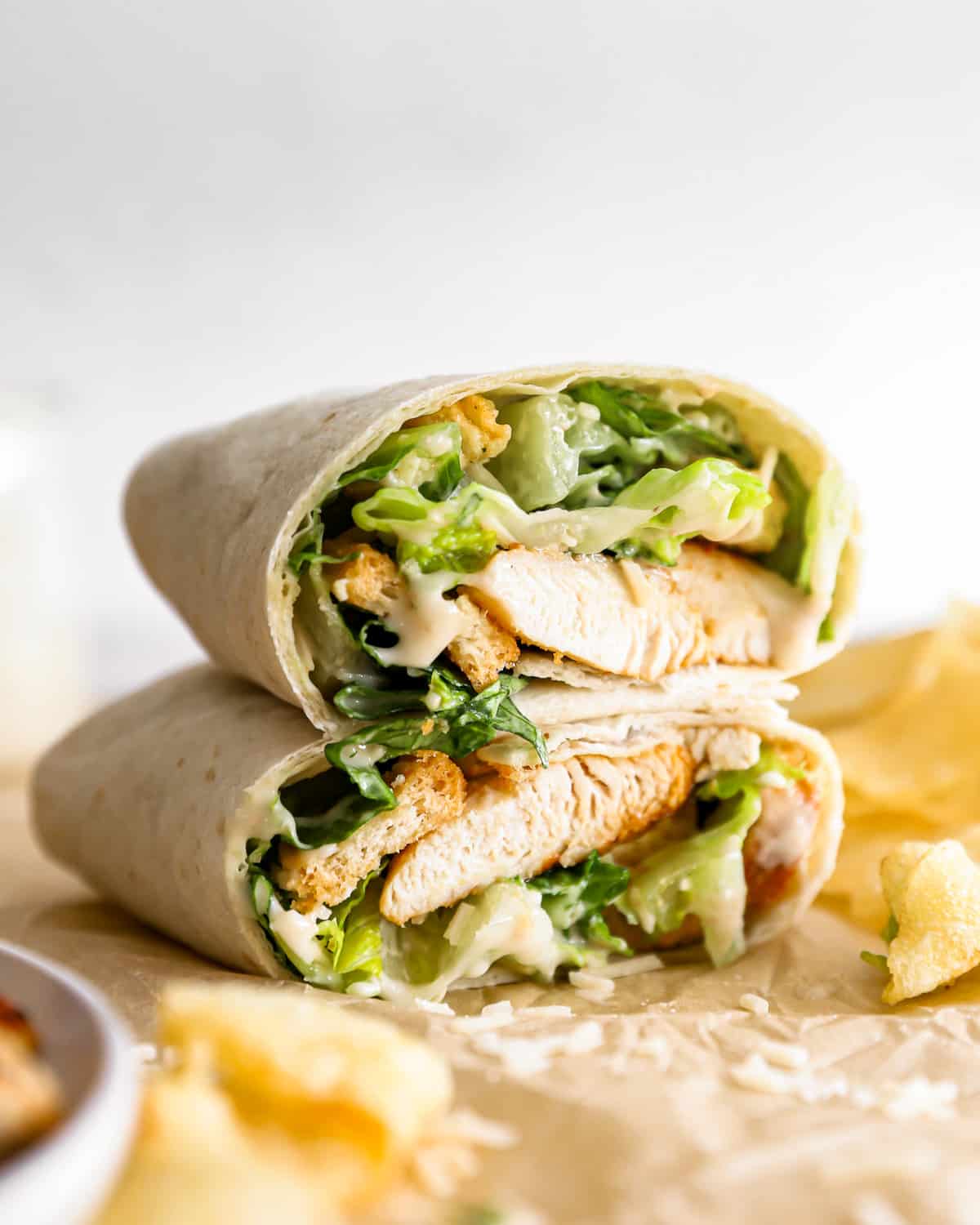 A chicken Caesar wrap cut in half and stacked on top of each other.