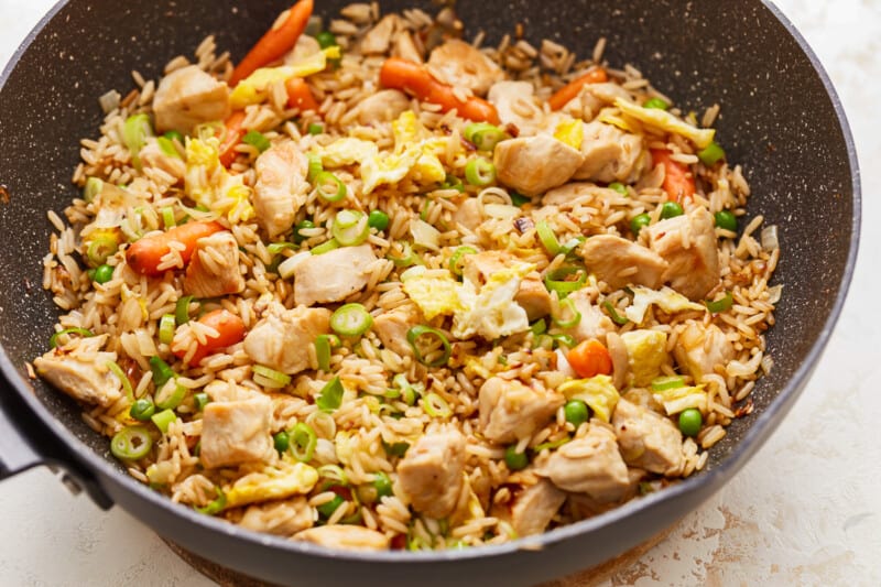 Fried rice with chicken and vegetables in a wok.
