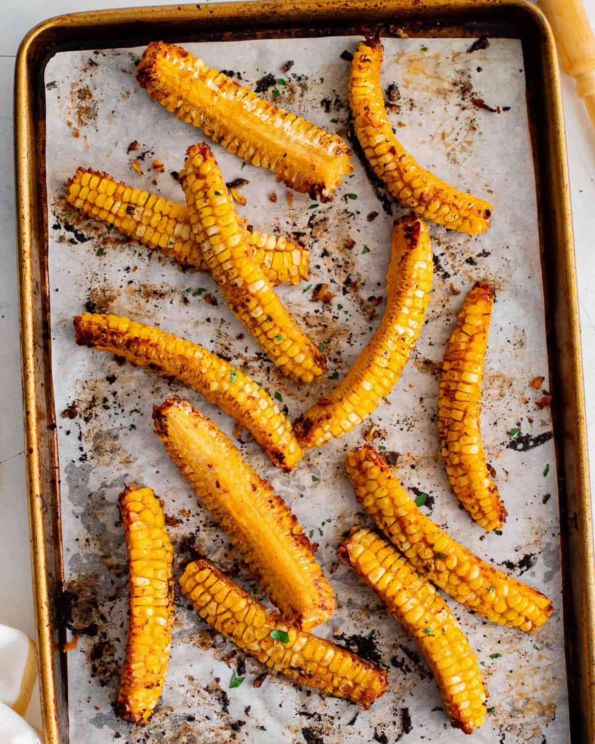 Corn on the cob arranged like ribs on a baking sheet.