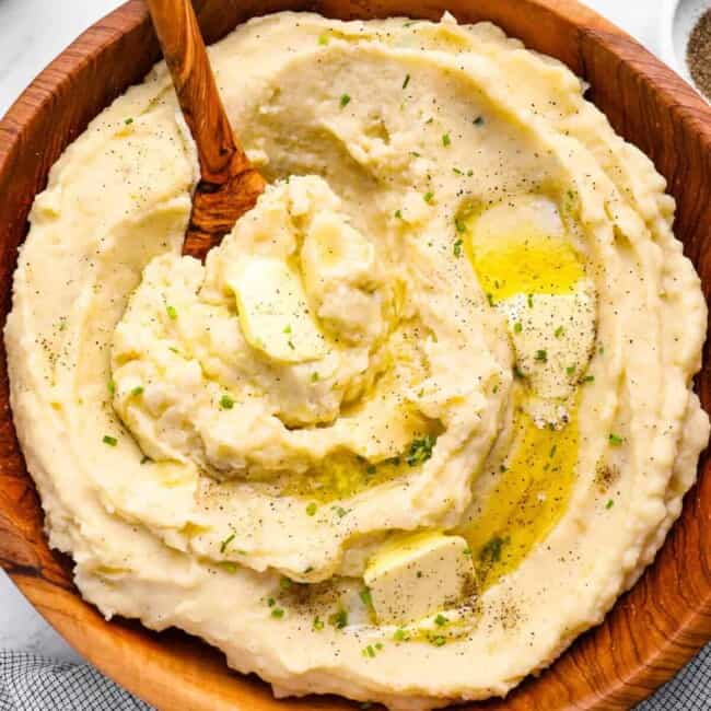 creamy crockpot mashed potatoes in a wooden serving bowl