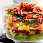 A salad with bacon and peas in a bowl.