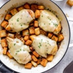 Chicken breasts in a skillet with croutons.