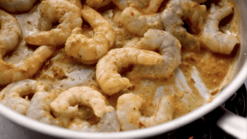 partially cooked shrimp in orange sauce.